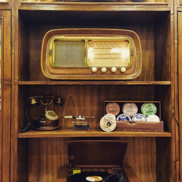 Scaffale vintage con prodotti per capelli nel barbershop BoyscluB a Palermo